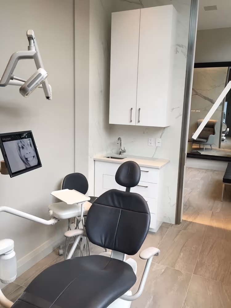 Smilebar treatment room with dental chair, monitor, and sleek cabinetry